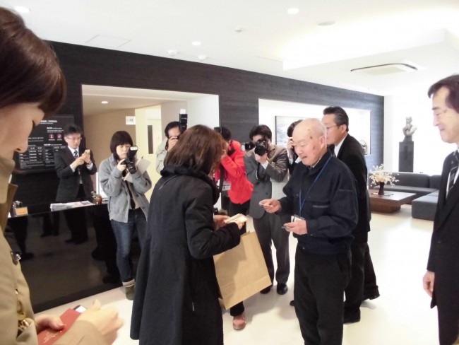 宮坂製糸所の宮坂社長からも記念品が!報道のカメラがたくさん向いています。